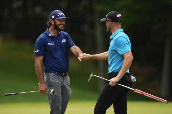 Max Homa, left, fist-bumps Wyndham Clark, right, after their putts on the 10th hole during the second round of the Travelers Championship golf tournament at TPC River Highlands, Friday, June 23, 2023, in Cromwell, Conn. (AP Photo/Frank Franklin II)