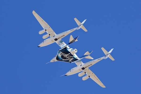 FILE - Virgin Galactic's VSS Unity departs Mojave Air & Space Port in Mojave, Calif., for the final time as Virgin Galactic shifts its SpaceFlight operations to New Mexico, Feb. 13, 2020. Virgin Galactic is aiming for early August 2023 for its next flight to the edge of space, a trip that is expected to include the first of many ticket holders who have been waiting years for their chance at weightlessness aboard the company's rocket-powered plane. (Matt Hartman via AP, File)