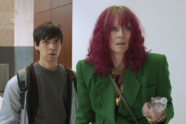 This image released by A24 Films shows Julio Torres, left, and Tilda Swinton in a scene from "Problemista." (A24 via AP)