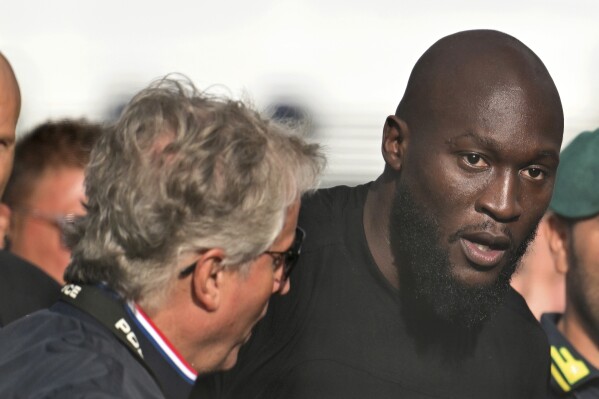 Romelu Lukaku, right, arrives in Rome, Tuesday Aug. 29, 2023. Romelu Lukaku has ended his standoff with Chelsea by flying into the Italian capital with the aim of joining Italian club Roma in a season-long loan deal that would see the Belgium striker look to revive his career in a third spell under coach Jose Mourinho. (Alfredo Falcone/LaPresse via AP)