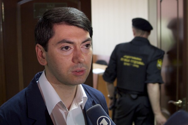 FILE - Golos' Deputy Director Grigory Melkonyants speaks to the media after a court session in Moscow, Russia, on Friday, June 14, 2013. The Russian authorities have opened a criminal probe against a leader of a prominent independent election monitoring group, his lawyer said Thursday, Aug. 17. (AP Photo, File)