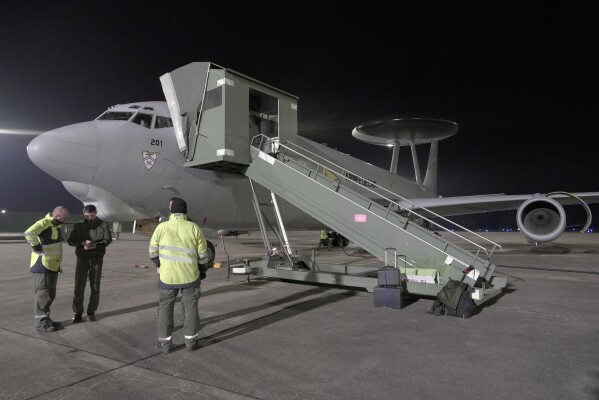 Crew members debrief ground staff after a 10-hour mission Tuesday, Jan. 9, 2024, aboard a French Air Force AWACS surveillance plane that flew from the 702 Air Base in Avord, central France, to eastern Romania and back again. Circling around and around for hours on auto-pilot high in the skies of eastern Europe, secretive surveillance flights for NATO closely watch Russian activity along the military alliance's eastern flank. (AP Photo/John Leicester)