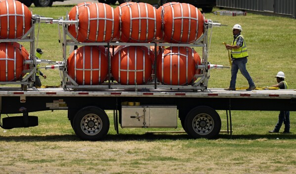 Dozens of large buoys that are set to be deployed in the Rio Grande are unloaded, Friday, July 7, 2023, in Eagle Pass, Texas, where border crossings continue to place stress on local resources. Advocates have raised concern that the barriers may have an adverse environmental impact. (AP Photo/Eric Gay)