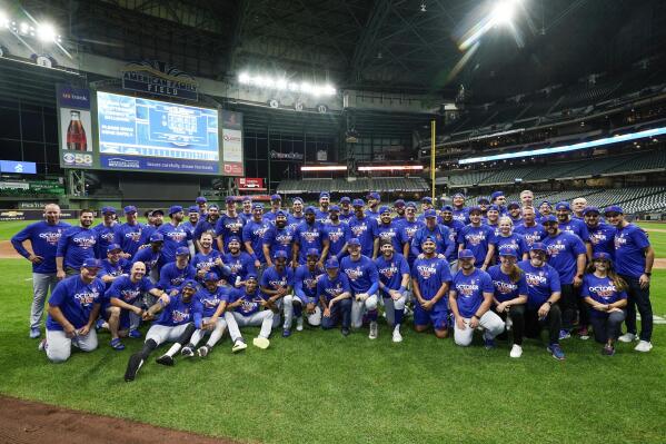 The New York Mets pose for a picture after a baseball game against the Milwaukee Brewers Monday, Sept. 19, 2022, in Milwaukee. The Mets won 7-2 to clinch a place in the postseason. (AP Photo/Morry Gash)