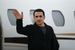 FILE - In this Jan. 21, 2016, file photo, Amir Hekmati waves after arriving on a private flight at Bishop International Airport in Flint, Mich. A judge on Monday, Oct. 2, 2017, ordered Iran to pay $63.5 million to Hekmati, a former U.S. Marine from Michigan who was jailed in that country for more than four years. (AP Photo/Paul Sancya, File)