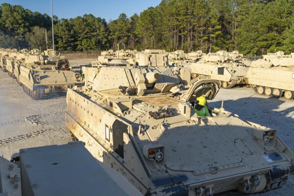 In this image provided by U.S. Transportation Command, a stevedore sits in a Bradley Fighting Vehicle before loading it onto the ARC Wallenius Wilhemsen Jan. 25, 2023, at the Transportation Core Dock in North Charleston, S.C. After months of agonizing, the U.S has agreed to send longer-range bombs to Ukraine as it prepares to launch a spring offensive to retake territory Russia captured last year, U.S. officials said Thursday, confirming that the new weapons will have roughly double the range of any other offensive weapon provided by America. (Oz Suguitan/U.S. Transportation Command via AP