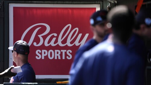 FILE -A Bally Sports sign hangs in a dugout before the start of a spring training baseball game between the St. Louis Cardinals and Houston Astros Thursday, March 2, 2023, in Jupiter, Fla. Major League Baseball says teams have collected 94% of the money they have been owed by Diamond Sports. The company owns 19 networks under the Bally Sports banner and has been in Chapter 11 bankruptcy proceedings in Texas since March. MLB took over rights to San Diego Padres telecasts on May 31 after a rights payment was missed.(AP Photo/Jeff Roberson, File)