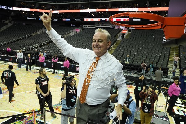 Texas head coach Vic Schaefer celebrates after cutting down the net after an NCAA college basketball game against Iowa State for the Big 12 women's tournament championship Tuesday, March 12, 2024, in Kansas City, Mo. Texas won 70-53. (AP Photo/Charlie Riedel)