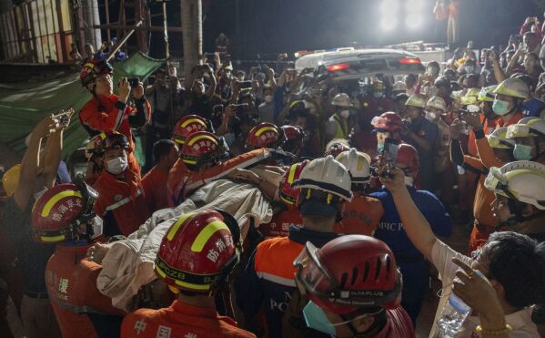 In this photo released by Xinhua News Agency, members of a China search and rescue team transfer a survivor from a collapsed Great Wall Hotel in the aftermath of an earthquake in Mandalay, Myanmar, Monday, March 31, 2025. (Cai Yang/Xinhua via AP)