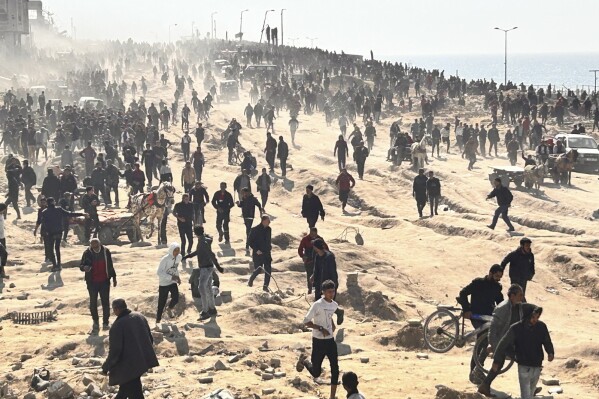 Palestinians wait for humanitarian aid on a beachfront in Gaza City, Gaza Strip, Sunday, Feb. 25, 2024. (AP Photo/Mahmoud Essa)