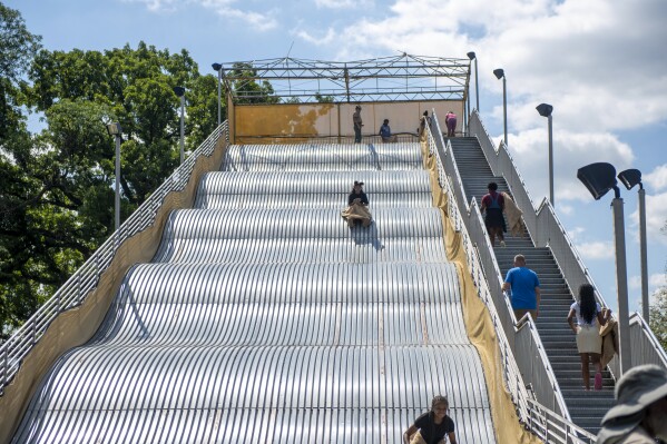 People ride the newly reopened Giant Slide at Belle Isle in Detroit on Friday, July 19, 2024. (Neo Hopkins/Detroit News via ĢӰԺ)