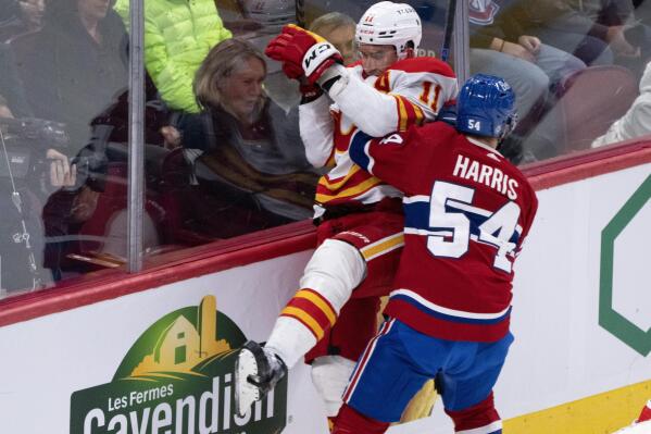 Calgary Flames' Mikael Backlund is checked by Montreal Canadiens' Jordan Harris during the second period of an NHL hockey game in Montreal, Monday, Dec. 12, 2022. (Paul Chiasson/The Canadian Press via AP)