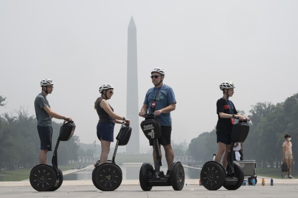 Tourists on Segways visit the Lincoln Memorial while the sky is hazy with smoke from wildfires in Canada, obscuring the view of the Capitol and other buildings along the National Mall almost completely past the Washington Monument, Thursday, June 29, 2023, in Washington. (AP Photo/Jacquelyn Martin)