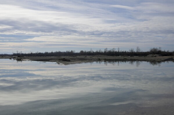 A view of the bank of the Drina River near the village of Amajlije, eastern Bosnia, Sunday, Feb. 4, 2024. In several cities along this river between Bosnia and Serbia, simple, durable gravestones now mark the final resting places of dozens of refugees and migrants who drowned in the area while trying to reach Western Europe. (AP Photo/Darko Vojinovic)