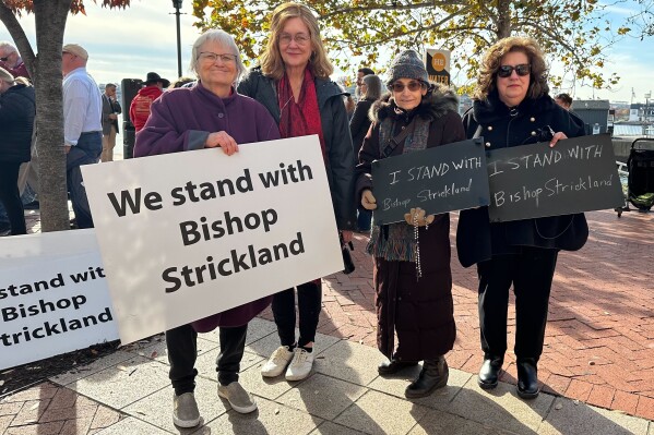 From left, Jacqueline Miller and Mary Rappaport, both from Alexandria, Va.; June Vendetti, from Bridgeport, Conn., and Suzanne Allen, from Westport, Conn., stand together for a photo in Baltimore on Wednesday, Nov. 15, 2023. They traveled to the U.S. Conference of Catholic Bishops support Bishop Joseph Strickland after his ouster. “We’re in a spiritual battle. When the pope asked Bishop Strickland to resign, it was a wound to the whole church,” Allen said. Rappaport said, “this pope is trying to change the church in dangerous ways.” (AP Photo/Tiffany Stanley)