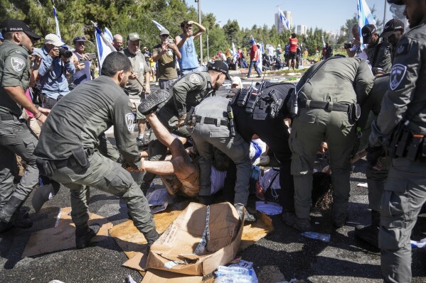 Israeli police disperse demonstrators blocking the road leading to the Knesset, Israel's parliament, during a protest against plans by Prime Minister Benjamin Netanyahu's government to overhaul the judicial system, in Jerusalem, Monday, July 24, 2023. The demonstration came hours before parliament is expected to vote on a key part of the plan. (AP Photo/Mahmoud Illean)