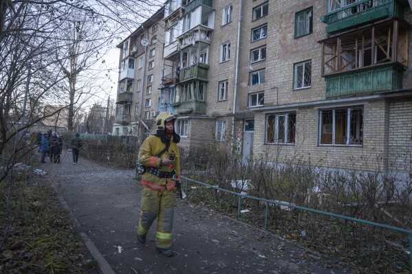 A firefighter examines damage in an apartment building following a Russian drone attack in Kyiv, Ukraine, Saturday, Nov. 25, 2023. Russia launched its most intense drone attack on Ukraine since the beginning of its full-scale invasion on Saturday morning, military officials said. (AP Photo/Efrem Lukatsky)