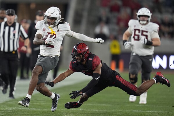 Washington State wide receiver Kyle Williams gets away from San Diego State cornerback Chris Johnson during the first half of an NCAA college football game Saturday, Oct. 26, 2024, in San Diego. (AP Photo/Gregory Bull)