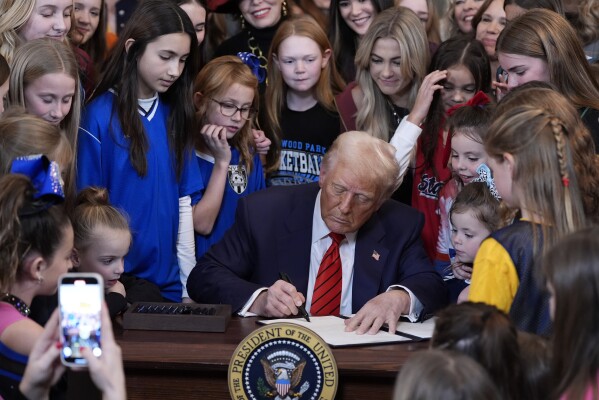 President Donald Trump signs an executive order barring transgender female athletes from competing in women's or girls' sporting events, in the East Room of the White House, Feb. 5, 2025, in Washington. 