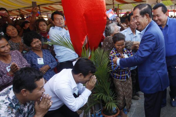 FILE - Cambodia's Prime Minister Hun Sen, second right, greets villagers on his arrival for a groundbreaking ceremony to build the country's first expressway, in Kampong Speu province, south of Phnom Penh, Cambodia, on March 22, 2019. Hun Sen on Wednesday June 7, 2023 presided over a groundbreaking ceremony for construction of the country’s second expressway, which will link the capital, Phnom Penh, to the eastern border with Vietnam. (AP Photo/Heng Sinith, File)