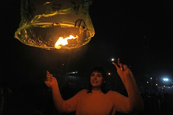 An Iranian woman releases a wishing lantern while celebrating Chaharshanbe Souri, or Wednesday Feast, an ancient Festival of Fire on the eve of the last Wednesday of the Persian year, in Tehran, Iran, Tuesday, March 18, 2025. (AP Photo/Vahid Salemi)