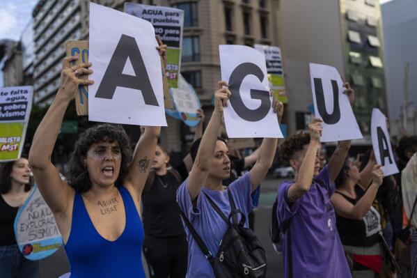 Activists hold signs that read water in Spanish, during a protest in the framework of World Water Day in Buenos Aires, Argentina, Wednesday, March 22, 2023. (AP Photo/Rodrigo Abd)