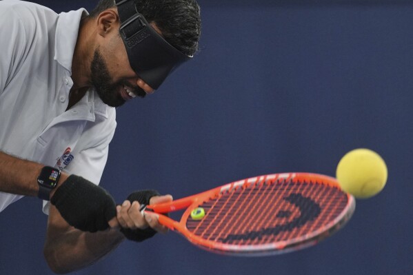 Blind tennis champion Naqi Rizvi plays a shot during a visually impaired tennis training session in London, Tuesday, May 20, 2025. (AP Photo/Kin Cheung)