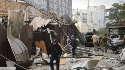 In this photo provided by the National Police of Ukraine, a police officer and a rescue worker walk in front of a restaurant RIA Pizza destroyed by a Russian attack in Kramatorsk, Ukraine, Tuesday, June 27, 2023. (National Police of Ukraine via AP)