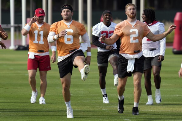 Tampa Bay Buccaneers quarterbacks John Wolford (11), Baker Mayfield (6) and Kyle Trask (2) run during NFL football practice Thursday, June 15, 2023, in Tampa, Fla. (AP Photo/Chris O'Meara)