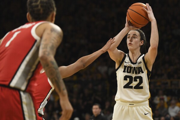 Iowa guard Caitlin Clark (22) takes a 3-point shot over Ohio State defenders during the second half of an NCAA college basketball game, Sunday, March 3, 2024, in Iowa City, Iowa. (AP Photo/Cliff Jette)