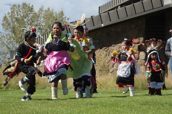 FILE - Hopi children dance in front of City Hall on Indigenous Peoples Day, Oct. 10, 2022, in Flagstaff, Ariz. Native American people will celebrate their centuries-long history of resilience on Monday, Oct. 9, 2023, through ceremonies, dances and speeches. The events across the United States will come two years after President Joe Biden officially commemorated Indigenous Peoples Day. (AP Photo/Felicia Fonseca, File)