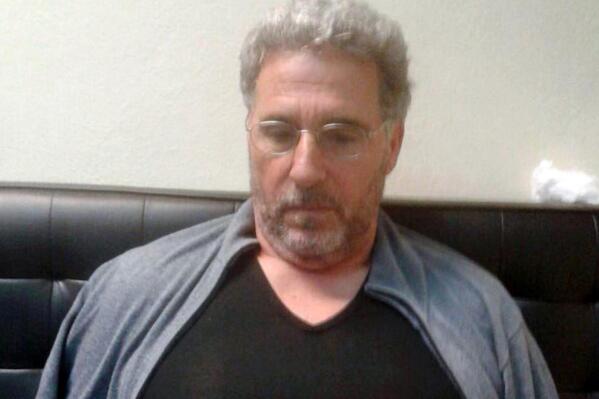 FILE - In this Sept. 3, 2017 file photo released by the Italian police, a man identified by police as longtime fugitive Rocco Morabito, looks down after being arrested at a hotel in Montevideo, Uruguay. A convicted Italian mobster, one of Italy's most sought-after fugitives, has been extradited from Brazil. Italian police said that Rocco Morabito, who was No. 2 on the list of Italy's most wanted mobsters, arrived on Wednesday, July 6, 2022 in the morning on a flight from Brazil. (Italian Police via AP, File)