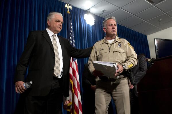 FILE - Clark County Commissioner Steve Sisolak, left, and Clark County Sheriff Joe Lombardo leave a media briefing at Metro Police headquarters in Las Vegas on Oct. 4, 2017. In 2017, Sisolak and Lombardo stood together in the national spotlight, kicking off a fund that raised millions of dollars for victims of the deadliest mass shooting in modern U.S. history on the Las Vegas Strip. There are no fond words now, with Sisolak seeking a second term as governor and Lombardo, with backing from former President Donald Trump, leading a Republican bid to unseat him in a key partisan race drawing national attention. (Steve Marcus/Las Vegas Sun via AP, File)