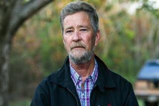 FILE - In this Dec. 5, 2018 file photo, Leslie McCrae Dowless Jr. poses for a portrait outside of his home in Bladenboro, N.C. Leslie McCrae Dowless Jr., faces 13 criminal counts related to activities from the 2016 and 2018 elections, including charges of obstruction of justice, possessing absentee ballots and perjury. A North Carolina judge on Monday, Nov. 15, 2021 set a trial date next August for the political operative accused of ballot fraud dating to 2016, including a 2018 congressional election whose results ultimately got tossed out. (Travis Long/The News & Observer via AP, File)