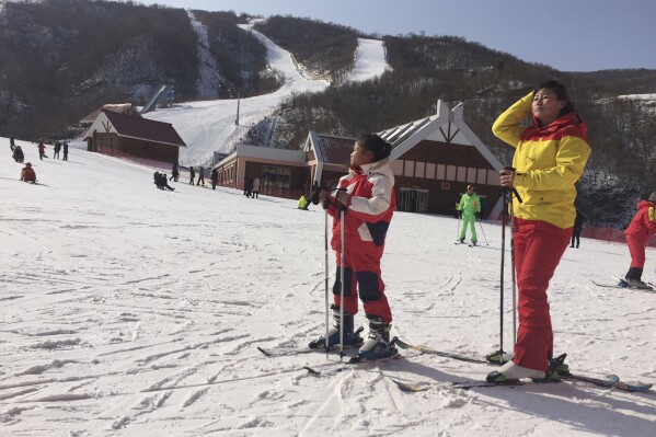 FILE - A mother and her daughter take a rest on the slopes at the Masik Pass ski resort in North Korea on Jan. 28, 2018. Russian tourists going on a ski trip will be the first international travelers to visit North Korea since the country's borders closed in 2020 amid the global pandemic lockdown, according to a report on the Russian state-run Tass news agency. (AP Photo/Eric Talmadge, File)