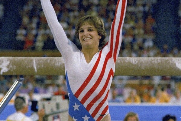 FILE- Mary Lou Retton reacts to applause after her performance at the Summer Olympics in Los Angeles on Aug. 3, 1984. Retton. 55, is in intensive care in a Texas hospital fighting a rare form of pneumonia, according to her daughter McKenna Kelley. (AP Photo/Suzanne Vlamis, File)