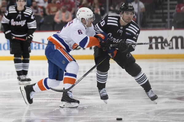 New York Islanders' Ryan Pulock (6) and New Jersey Devils' Timo Meier (28) compete for the puck during the second period of an NHL hockey game in Newark, N.J., Monday, April 15, 2024. (AP Photo/Seth Wenig)