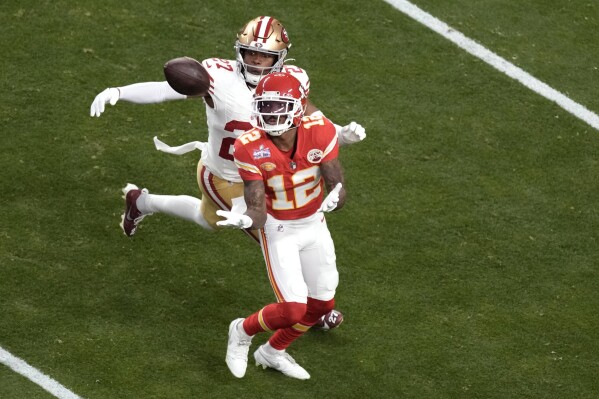 Kansas City Chiefs wide receiver Mecole Hardman Jr. (12) catches a pass in front of San Francisco 49ers safety Ji'Ayir Brown (27) during the first half of the NFL Super Bowl 58 football game Sunday, Feb. 11, 2024, in Las Vegas. (AP Photo/Charlie Riedel)