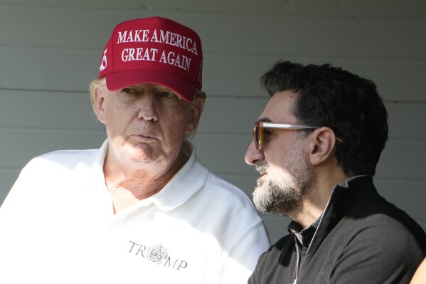 Former President Donald Trump talks with Yasir Al-Rumayyan, during the first round of the LIV Golf Tournament at Trump National Golf Club, in Sterling, Va., May 26, 2023. (AP Photo/Alex Brandon, File)