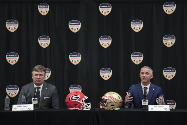 Georgia head coach Kirby Smart, left, and Florida State head coach Mike Norvell answer questions during a press conference one day ahead of the Orange Bowl NCAA college football game, in Dania Beach, Friday, Dec. 29, 2023. Georgia and Florida State will play in the Orange Bowl Saturday at Hard Rock Stadium in Miami Gardens. (AP Photo/Rebecca Blackwell)