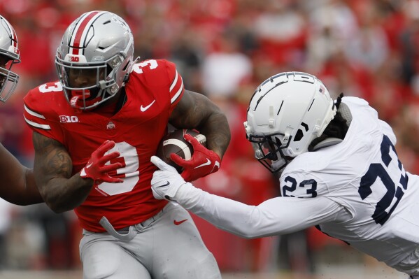 Ohio State running back Miyan Williams, left, cuts up field against Penn State linebacker Curtis Jacobs during the first half of an NCAA college football game Saturday, Oct. 21, 2023, in Columbus, Ohio. (AP Photo/Jay LaPrete)