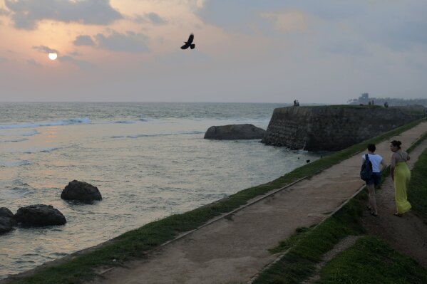 
              In this Friday, May 10, 2019, photo, foreign tourists walk on the rampart of the 17th century built Dutch fort in Galle, Sri Lanka. Sri Lanka was the Lonely Planet guide’s top travel destination for 2019, but since the Easter Sunday attacks on churches and luxury hotels, foreign tourists have fled. More than 250 people, including 45 foreigners who are mostly from China, India, the U.S. and the U.K., died in the series of suicide bombings by Islamic State and its local affiliates in churches and hotels in the capital, Colombo, and across the country on April 21. (AP Photo/Eranga Jayawardena)
            