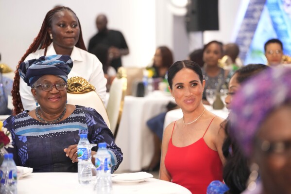 Meghan, the Duchess of Sussex, right, sits by Ngozi Okonjo-Iweala, Director-General of the World Trade Organization, during an event in Abuja, Nigeria, Saturday, May 11, 2024. Meghan, the Duchess of Sussex, says it’s been “humbling” to find out through a genealogy test that she is partly Nigerian. She was speaking at a meeting with Nigerian female industry leaders at an event on Saturday, her second day in the West African nation where she is visiting with Harry, her husband. (AP Photo/Sunday Alamba)