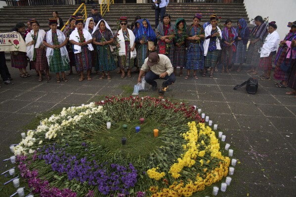 Indigenous women stand next to an altar they created outside the Supreme Court as they wait for an expected ruling, by a different court, in a case against three former paramilitary fighters who were trained by the military and are accused of raping 36 women four decades ago during Guatemala's civil war, in Guatemala City, Friday, May 30, 2025. (AP Photo/Moises Castillo)