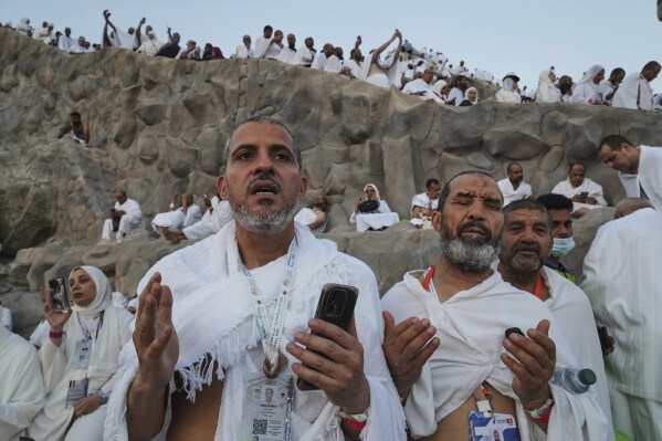 Muslim pilgrims offer prayers at top of the rocky hill known as the Mountain of Mercy, on the Plain of Arafat, during the annual Hajj pilgrimage near the holy city of Mecca, Saudi Arabia, Thursday, June 5, 2025. (AP Photo/Amr Nabil)