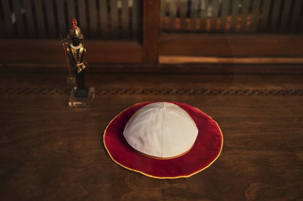 A Pope skullcap lays in the display window of the Gammarelli ecclesiastic clothes tailor shop in Rome, Wednesday, April 30, 2025. (AP Photo/Francisco Seco)