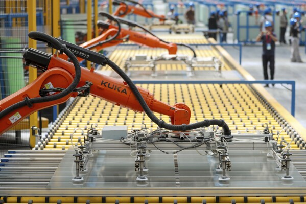 Kuka robots work on the production line of flat glass for solar panels at a subsidiary plant of Hoshine Silicon Industry in northwestern China's Xinjiang Uyghur Autonomous Region Friday, May 24, 2024. Factory activity in China slowed more than expected in May, suggesting further pressure on an economy already burdened by a prolonged crisis in the property industry, according to an official survey released Friday, May 31, 2024. (Chinatopix Via AP)