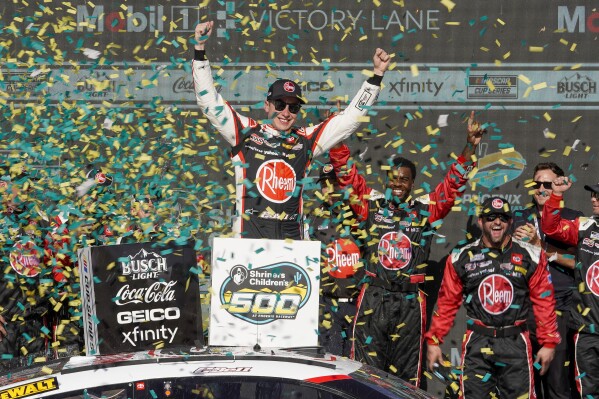 Christopher Bell, center, celebrates after his NASCAR Cup Series auto race win at Phoenix Raceway, Sunday, March 10, 2024, in Avondale, Ariz. (AP Photo/Darryl Webb)