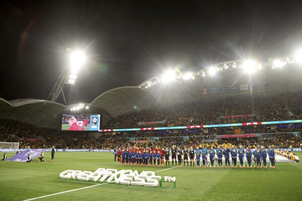 Canada, left, and Australia players line up for the national anthems before the Women's World Cup Group B soccer match between Australia and Canada in Melbourne, Australia, Monday, July 31, 2023. (AP Photo/Hamish Blair)