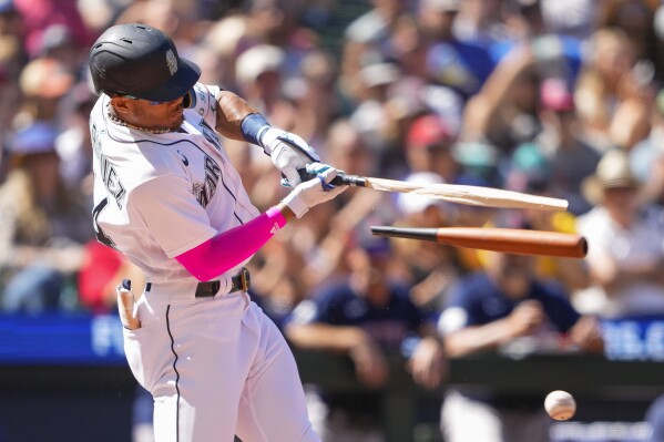 Seattle Mariners' Julio Rodriguez breaks his bat on an RBI single against the Boston Red Sox to score Tom Murphy during the seventh inning of a baseball game, Wednesday, Aug. 2, 2023, in Seattle. (AP Photo/Lindsey Wasson)